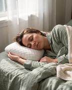 Velmesta Ear Piercing Donut Pillow used while side sleeping in pajamas in a sunlit bedroom