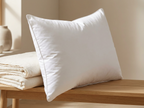 Velmesta Cloud Down Pillow leaning against folded linens