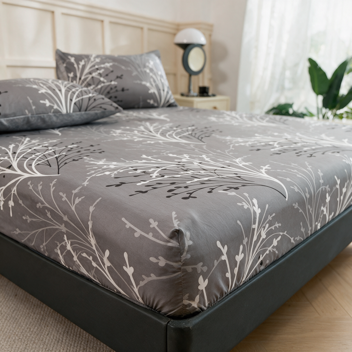Grey branch print fitted sheet on a made bed