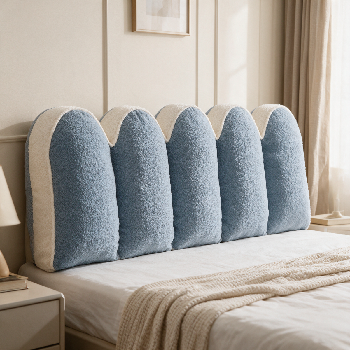 Blue and cream petal headboard reading cushion on a bed
